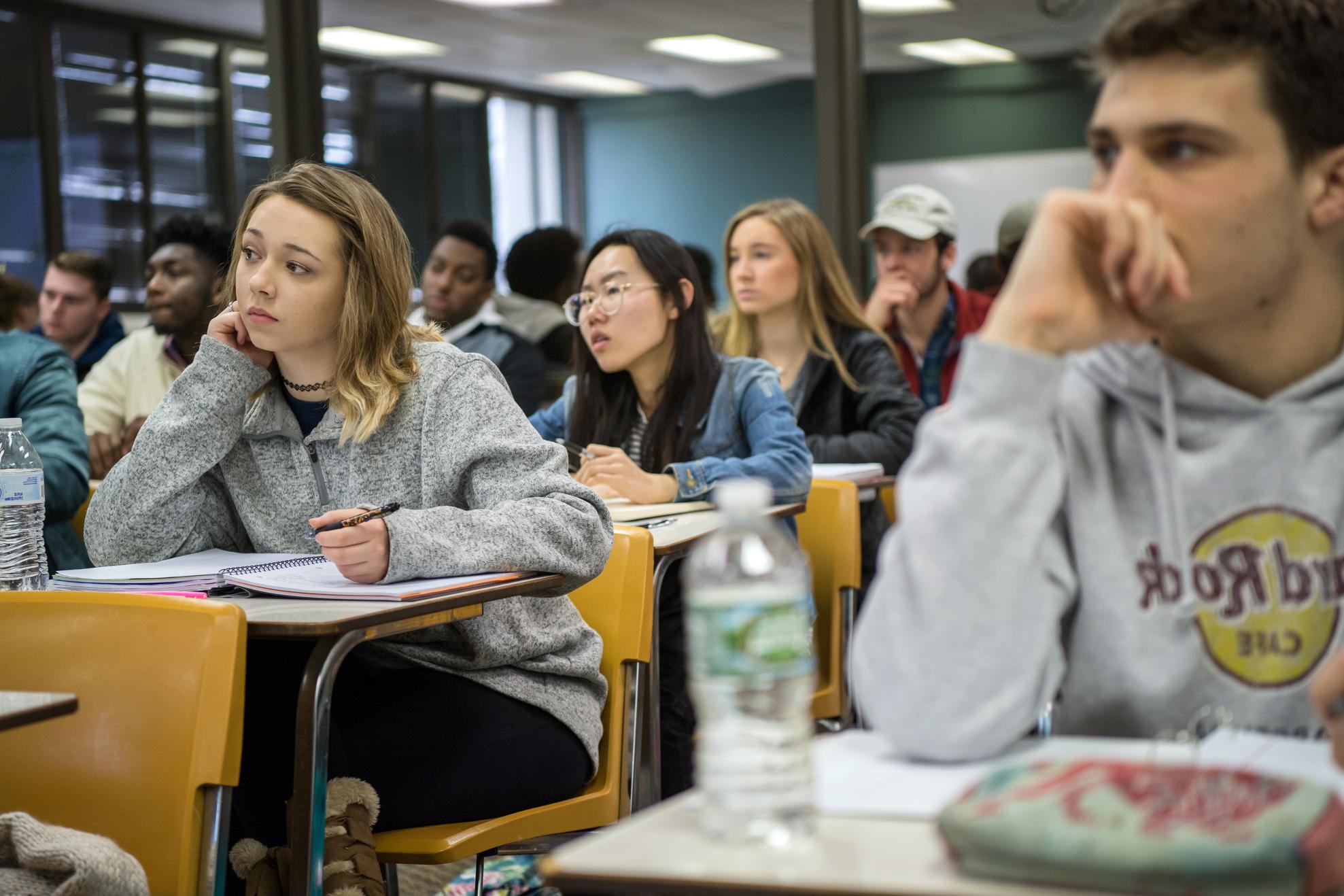 Students engaged and taking notes in lecture course.